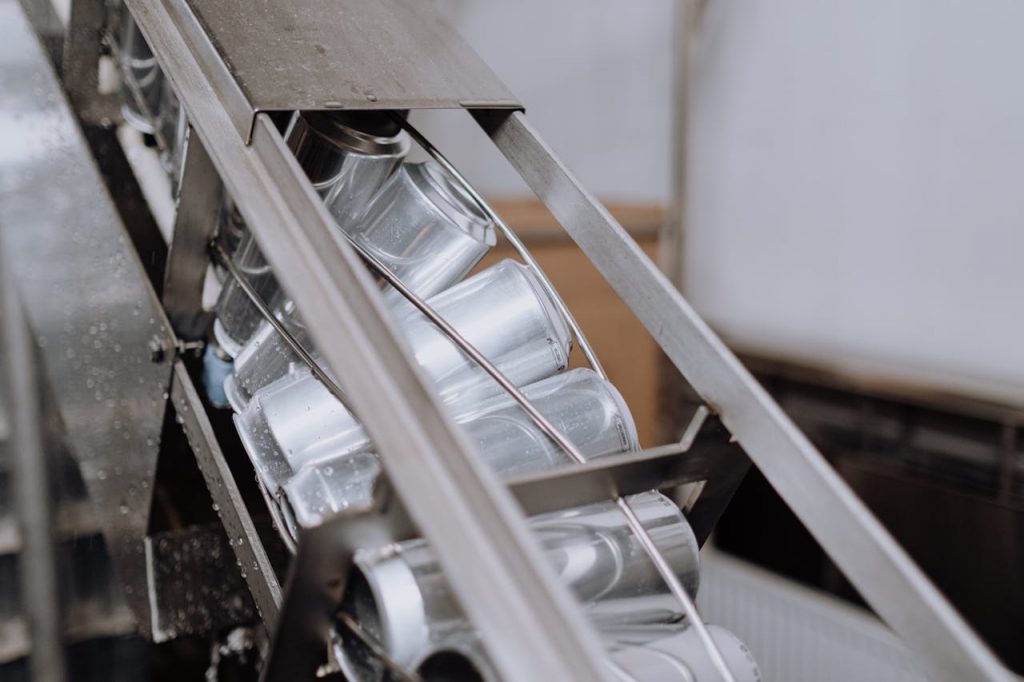 Close-up of automated canning equipment in a brewery showcasing production efficiency.
